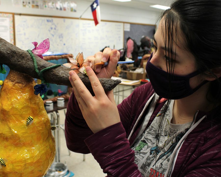 Senior Bailey Dunston puts some finishing touches on her art piece before the exhibit at the Ellen Noel Art Museum.