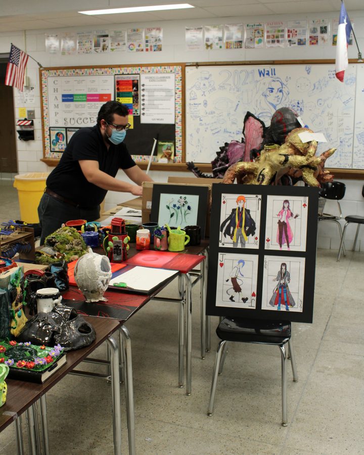 Art teacher Luis Trejo-Fuentez does last minute adjustments to his students art pieces before taking them to the Ellen Noel Art Museum for the High School Art Exhibit.